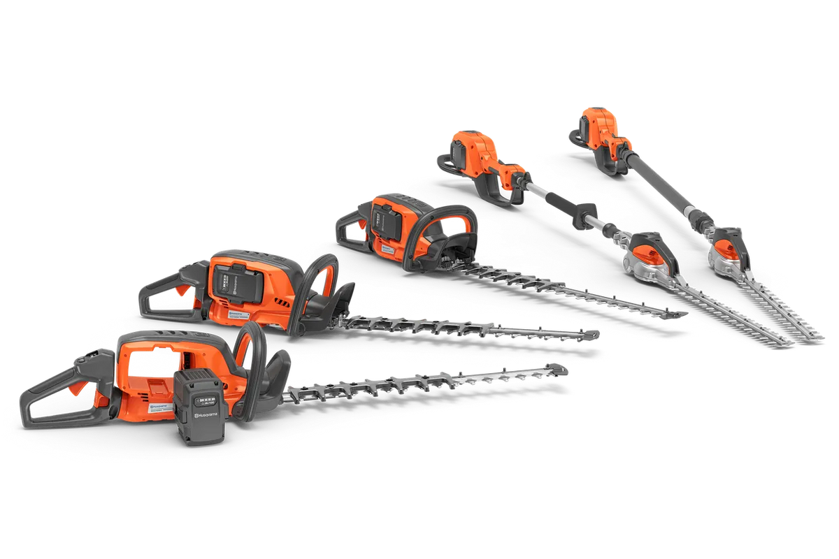 Husqvarna 520iHE3 stanghækkeklipper – uden batteri – Set fra siden af forskellige Husqvarna-hækkeklippere, herunder stanghækkeklippere, arrangeret i studieomgivelser.
